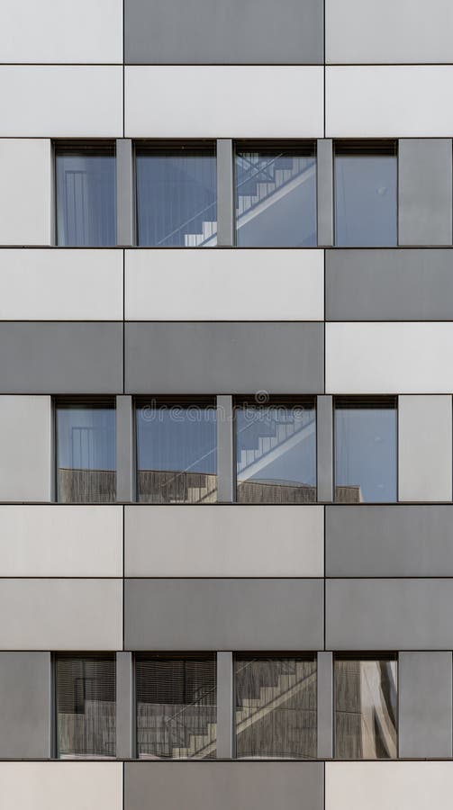 Modern facade front of modern business office building with stainless steel cladding in different grey tones