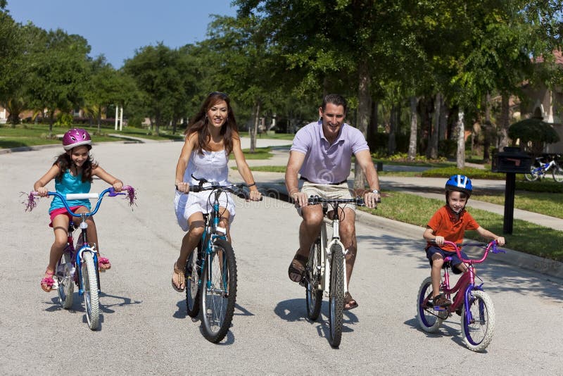 Familia de dos padres dos, chico, montando una bici común.