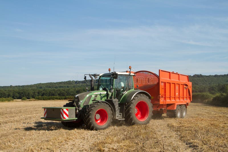 Modern Fendt tractor pulling orange trailer royalty free stock photo