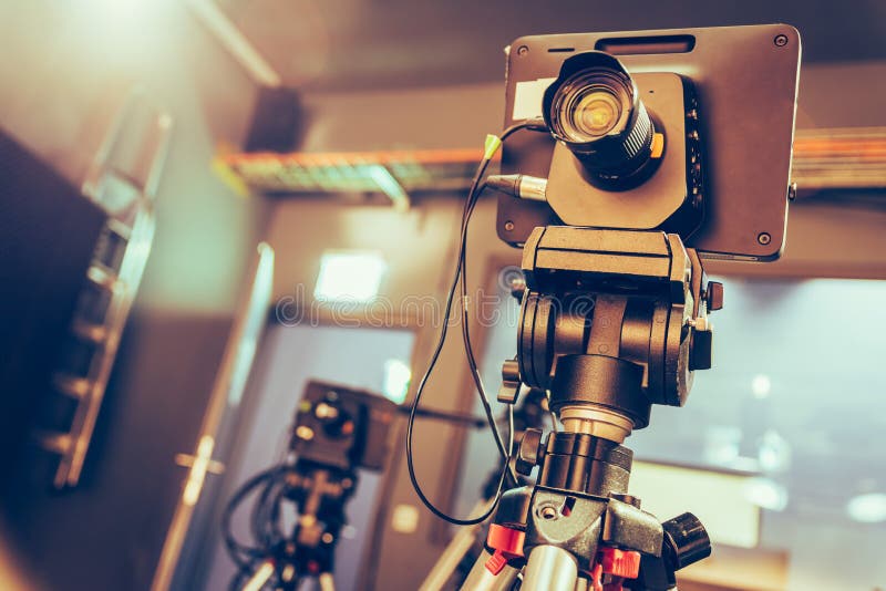 Modern Film Camera on a Tripod in a Broadcasting Studio, Spotlights and
