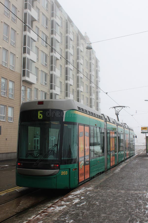 Helsinki, Finland, March 2012. Modern Finnish green tram at a bus stop on a foggy morning. stock image Helsinki, Finland, March 2012. Modern Finnish green tram at a bus stop on a foggy morning. stock image