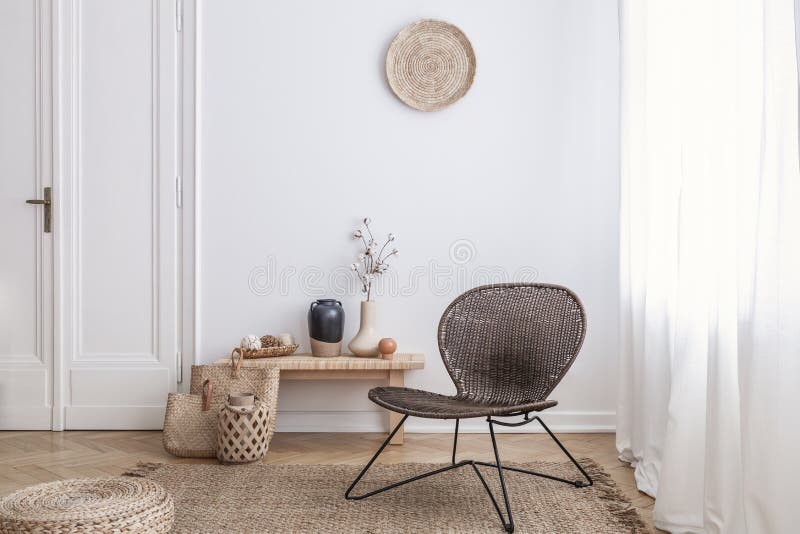 Modern fåtölj och puff på brun matta i den vita lägenhetinre med dörren Verkligt foto royaltyfria foton