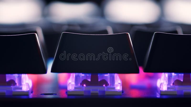 Modern gaming keyboard close-up with beautiful color backlight. Macro shooting of the rgb computer keyboard with backlight. Keyboard keys - macro shot. Low angle view with soft focus