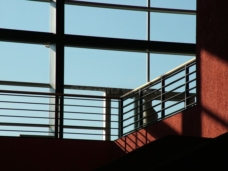 Big windows on a modern glass wall building and a staircase with fence. Impressive indoor interior architecture. Big windows on a modern glass wall building and a staircase with fence. Impressive indoor interior architecture.