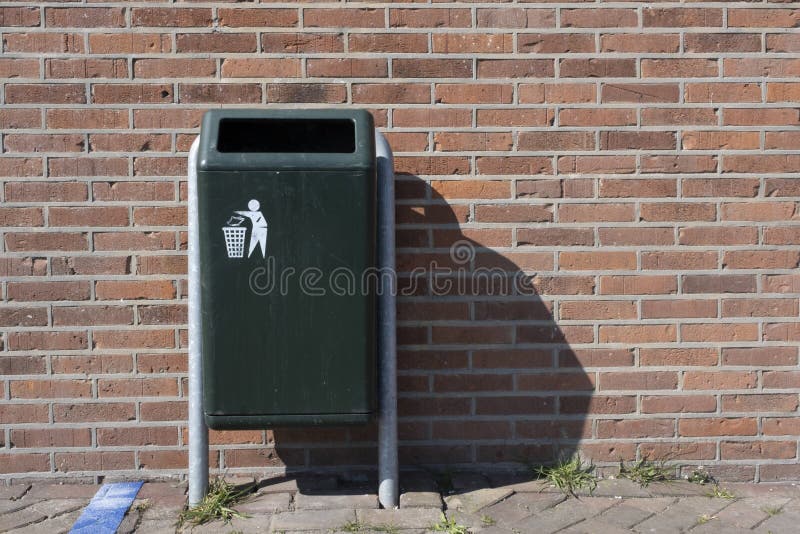 Modern Green Metallic Trash Bin in a Sunny Urban Environment Stock