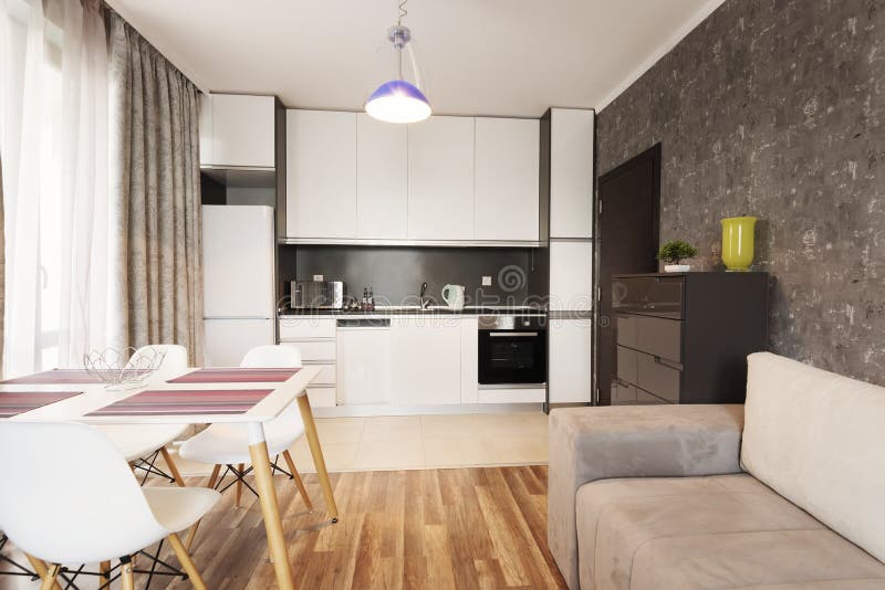 Modern helder en comfortabel woonkamer binnenlands ontwerp met bank, eettafel en keuken Grijze en witte zitslaapkamer royalty-vrije stock foto's Modern helder en comfortabel woonkamer binnenlands ontwerp met bank, eettafel en keuken Grijze en witte zitslaapkamer royalty-vrije stock foto's
