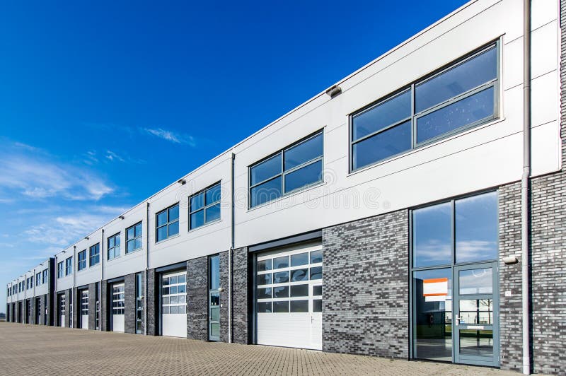 Modern industrial building with loading doors and blue sky royalty free stock image