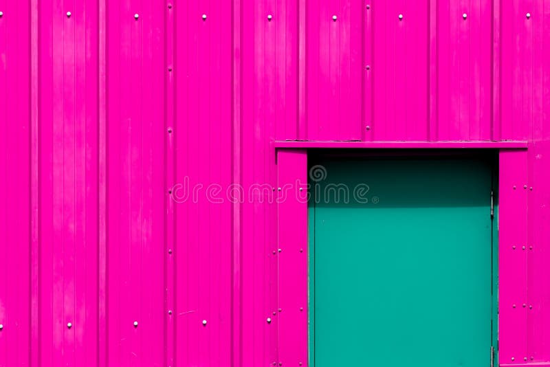 Modern industrialism Rosa byggnad för neon med den gröna dörren Vibran arkivfoto Modern industrialism Rosa byggnad för neon med den gröna dörren Vibran arkivfoto