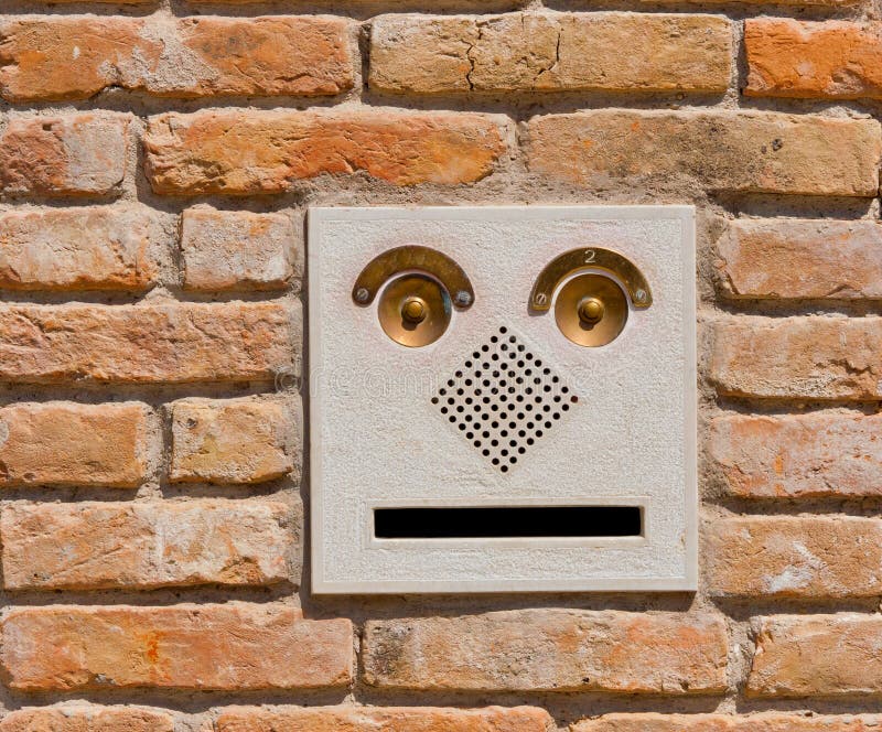 A modern intercom doorbell panel on old brick wal