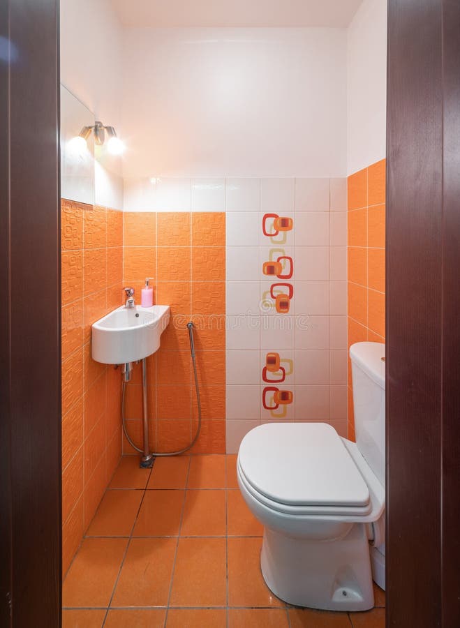 Modern Interior of Bathroom. Orange Tile. Sink and Toilet. Stock Image