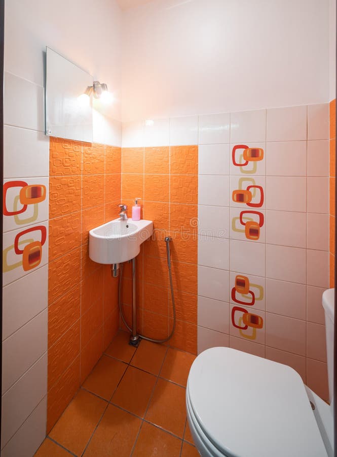 Modern Interior of Bathroom. Orange Tile. Sink and Toilet. Stock Photo