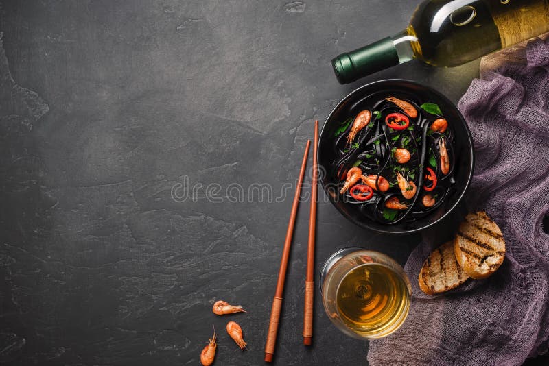 Modern japanese dinner, Mediterranean food, black cuttlefish ink spaghetti pasta with seafood, olive oil and basil, on dark rusty royalty free stock image Modern japanese dinner, Mediterranean food, black cuttlefish ink spaghetti pasta with seafood, olive oil and basil, on dark rusty royalty free stock image