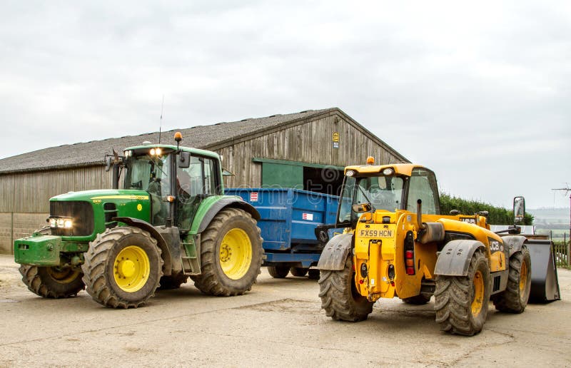 Modern John Deere tractor and trailer parked with jcb loader