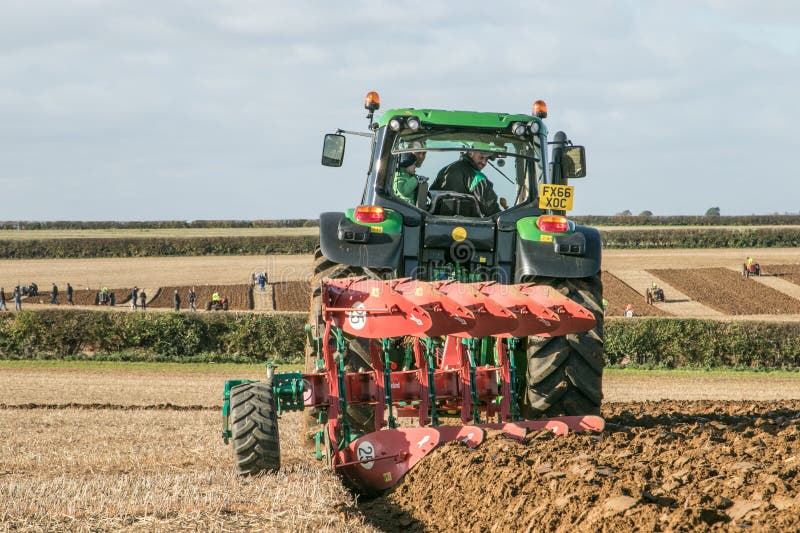 Modern John Deere traktor som drar en plöja
