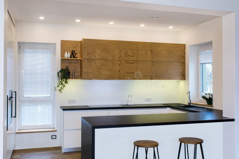Modern keukenontwerp in licht binnenland met houten accenten royalty-vrije stock afbeelding Modern keukenontwerp in licht binnenland met houten accenten royalty-vrije stock afbeelding