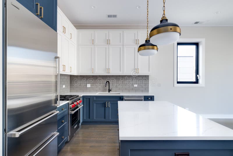 A modern kitchen with blue and white cabinets.