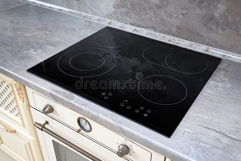 Stove and cooker red hot. Induction, ceramic cooktop, electric stovetop and  hob in kitchen. Warm plate ready for cooking. Contemporary interior design,  modern counter and wood table., Stock image