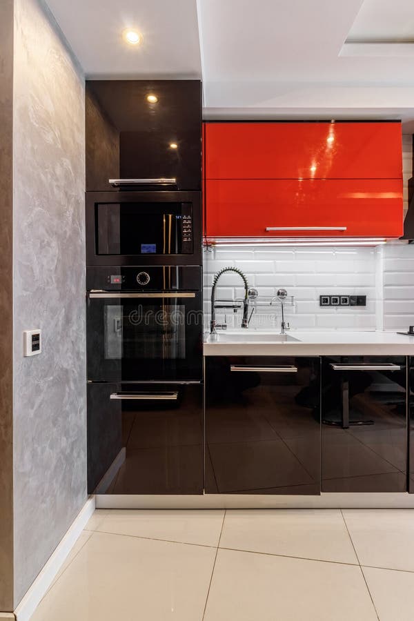 Modern kitchen interior with red and black cabinets and white ceramic floor