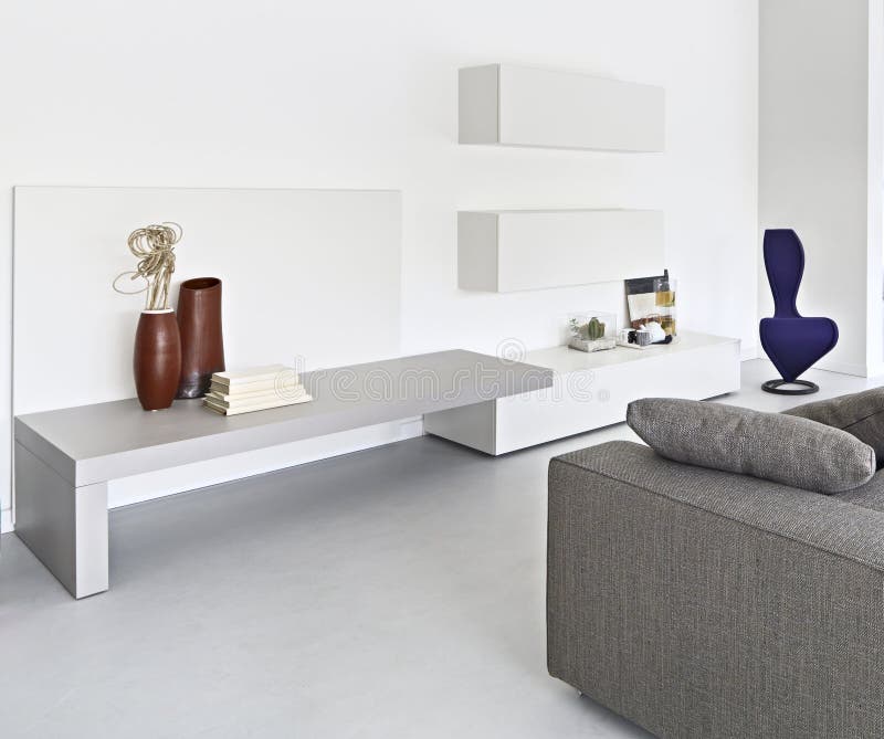 Interior view of a modern living room with fabric sofa and concrete floor