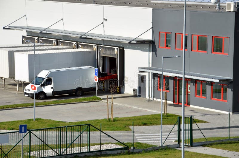 Modern Logistics Center, White Van and Trailers Standingon Ramp Stock