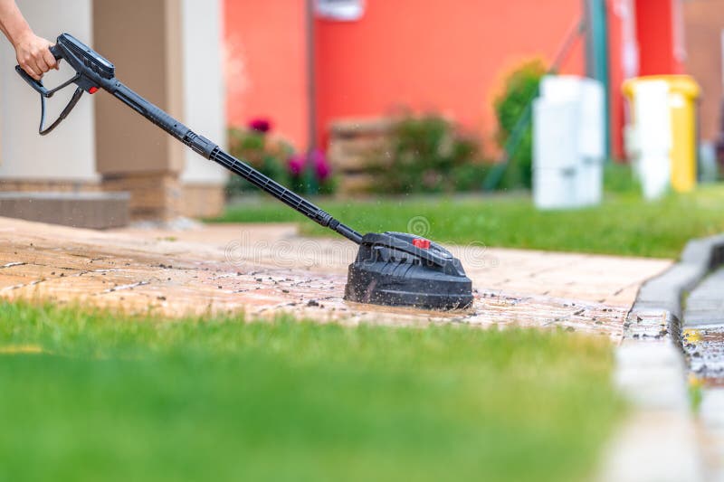 Modern Machine Cleaning Concrete Pavement in Front of the House with a