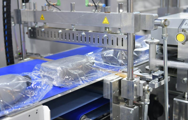 Modern Machine for Packaging Products on Conveyor Belt in Factory Stock