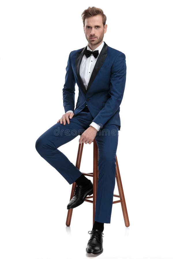 Modern man on a stool with hand on leg