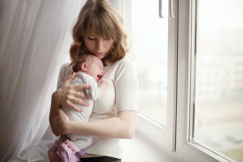 Modern med gullig liten gråt behandla som ett barn royaltyfri foto Modern med gullig liten gråt behandla som ett barn royaltyfri foto