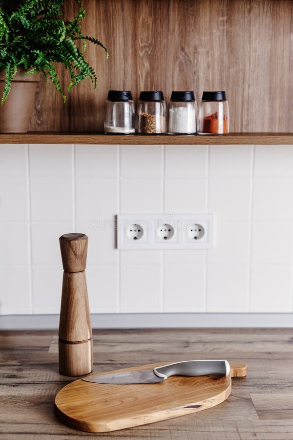 Modern mes op houten scherpe raad met peperkruid op houten lijstbovenkant Het koken op moderne keuken met meubilair in grijze kle stock fotografie Modern mes op houten scherpe raad met peperkruid op houten lijstbovenkant Het koken op moderne keuken met meubilair in grijze kle stock fotografie