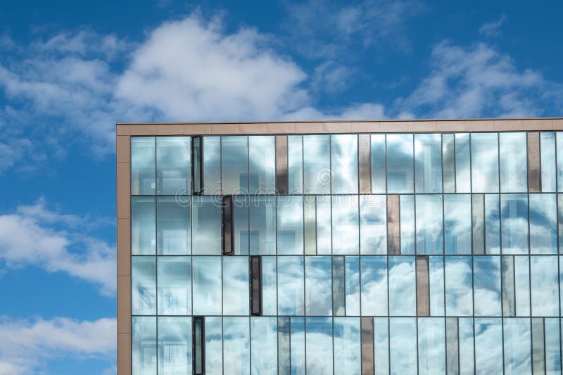 Modern minimalist glass building with clouds and sky reflecting royalty free stock photos