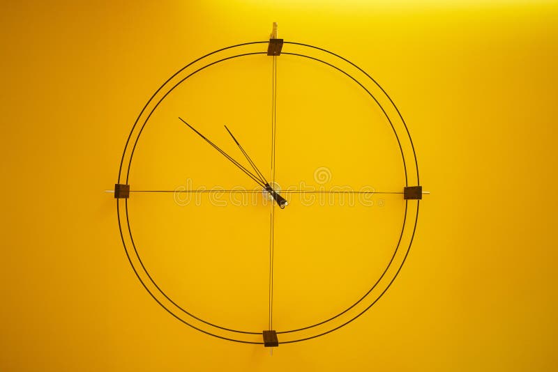 Modern Minimalist Loft Style Wall Clock on Yellow Wall. Stock Image