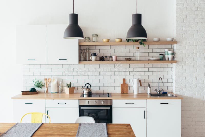 Modern nieuw licht binnenland van keuken met witte meubilair en eettafel