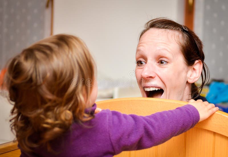Modern och barnet spelar peekaboo eller tittut royaltyfria bilder Modern och barnet spelar peekaboo eller tittut royaltyfria bilder