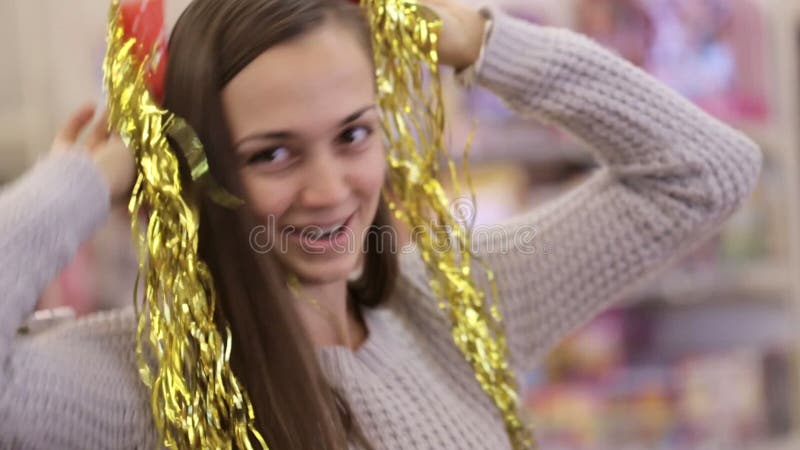 Modern och dottern som har gyckel med, dekorerar för xmas-träd på supermarket