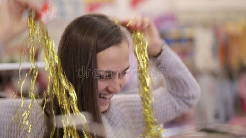 Modern och dottern som har gyckel med, dekorerar för xmas-träd på supermarket