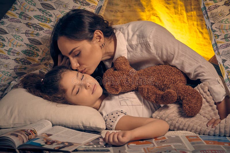 Modern och hennes dotter? r i ett tipit? lt med n? gra kuddar lycklig familj royaltyfri bild