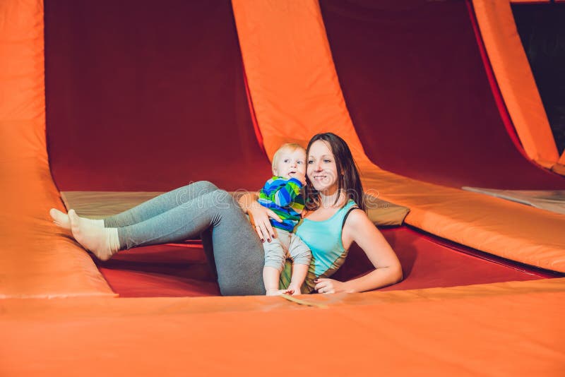 Modern och hennes sonbanhoppning på en trampolin i kondition parkerar och D royaltyfri fotografi Modern och hennes sonbanhoppning på en trampolin i kondition parkerar och D royaltyfri fotografi