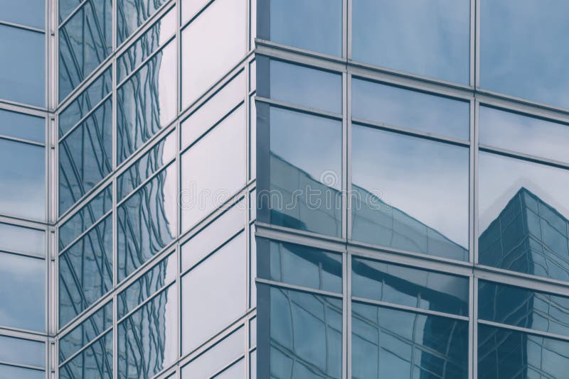 Modern office glass building texture in light blue tones for business background, business center generic facade, corner view