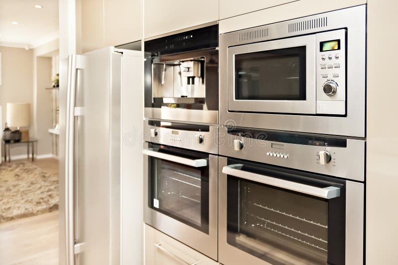 Modern Oven and Refrigerator Fixed To the Wall with Pantry Stock Image