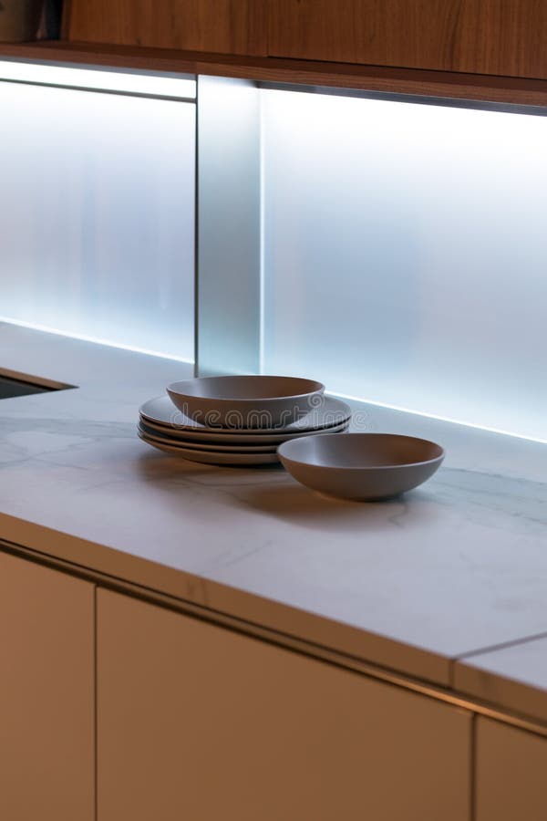 Modern Plates on Kitchen Countertop in the Soft Light from Luminous