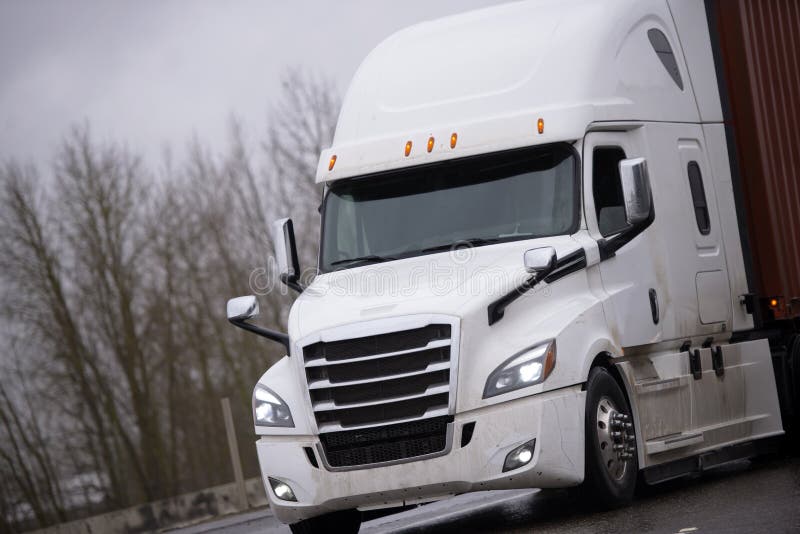 Modern big rig semi truck tractor transporting container with co stock photography