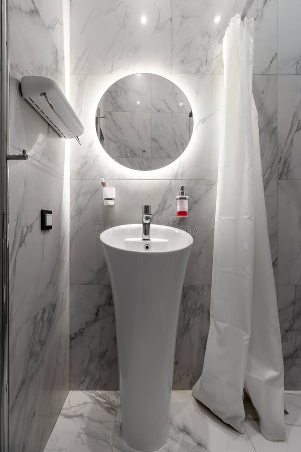 Modern Renovated Bathroom with a White Shell, Mirror and Marble Wall