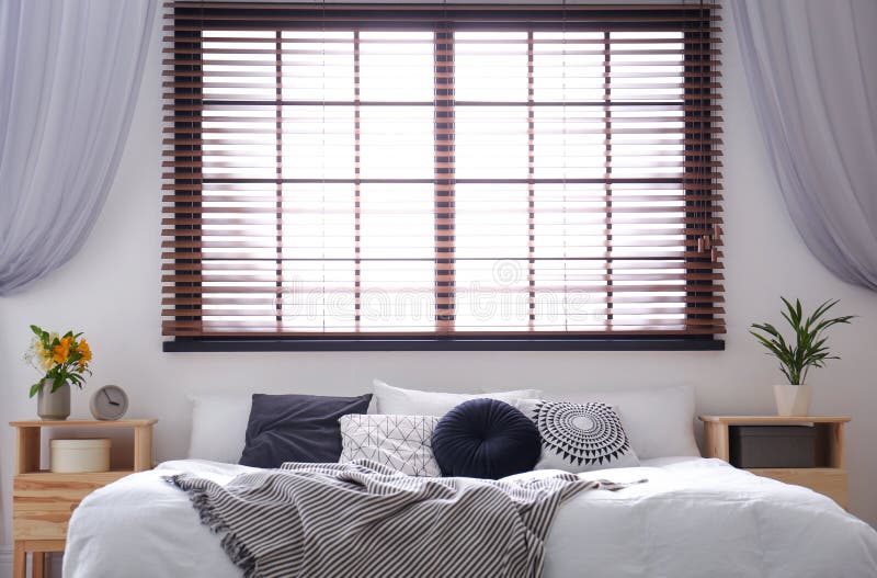 Modern room interior with double bed and window blinds