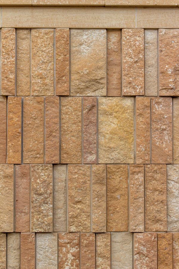 Modern rough textured limestone wall background with vertical aligned stone bricks