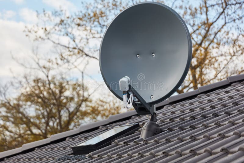 Modern Satellite Dish on the Roof of the House for TV Stock Photo