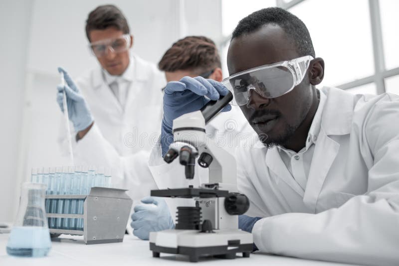 Modern scientist looking through a microscope stock image Modern scientist looking through a microscope stock image