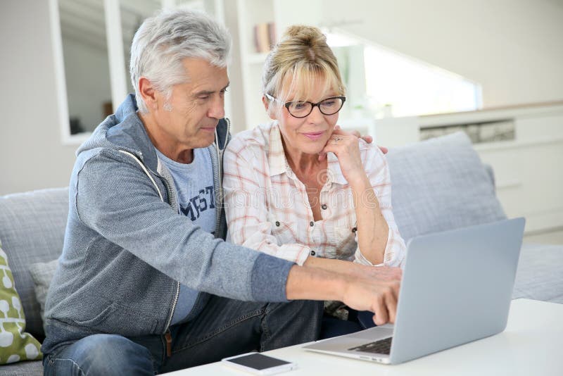 Modern senior couple at home using laptop royalty free stock photos