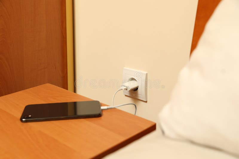 Modern Smartphone Charging from Electric Socket Indoors Stock Image