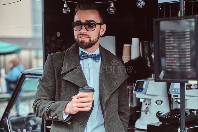 Modern Smiling Man in Sunglasses is Drinking Coffee while Standing ...