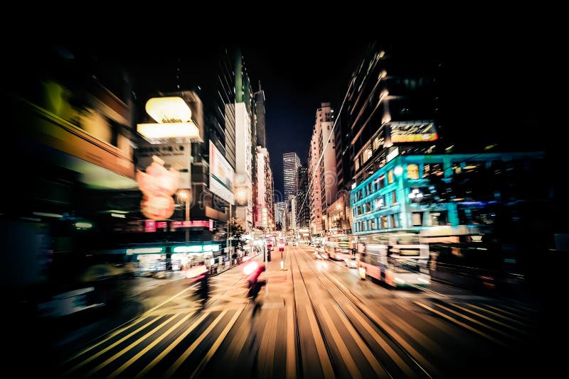 Moving through modern city street with illuminated skyscrapers. Hong Kong. Abstract cityscape traffic background with people silhouettes at zebra crossroad. Motion blur, art toning. Moving through modern city street with illuminated skyscrapers. Hong Kong. Abstract cityscape traffic background with people silhouettes at zebra crossroad. Motion blur, art toning